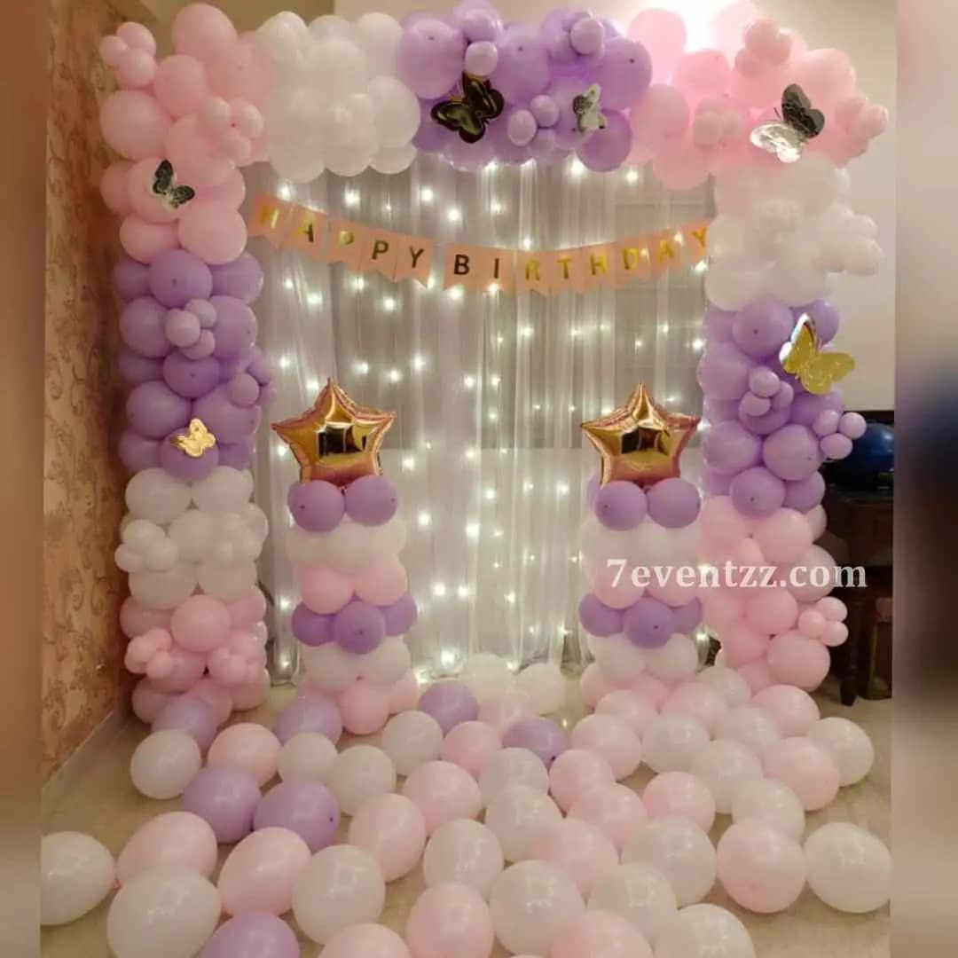 Butterfly pastel theme kids birthday decoration with soft pink, lilac, and mint green balloons, butterfly cutouts, and dreamy pastel backdrop