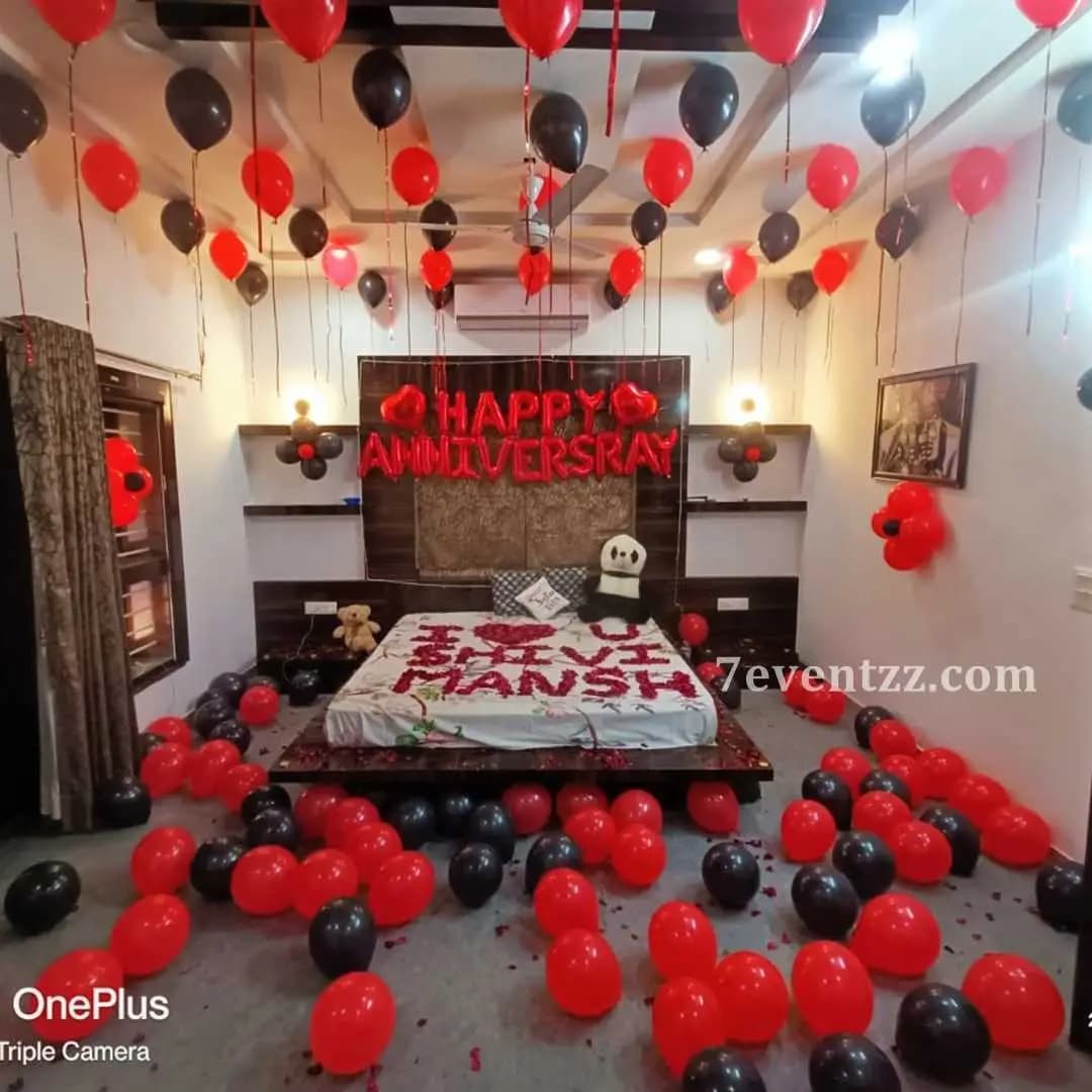 Happy Anniversary room decoration with red and white balloons, heart foil balloons, and LED lights