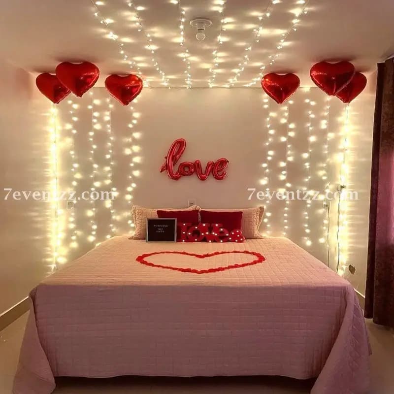Romantic anniversary decoration with fairy lights, candles, and soft balloon setup for couples