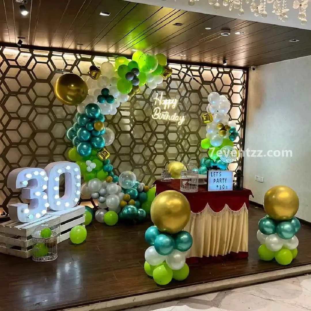 30th birthday milestone stage decoration with themed backdrop and balloon styling