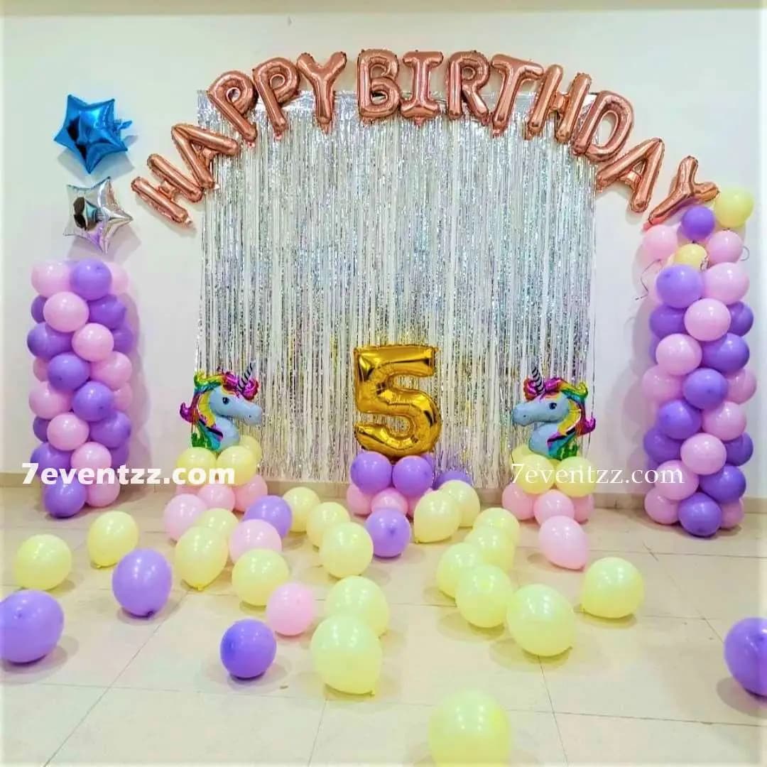 Unicorn theme birthday decoration setup with pastel balloons and unicorn character elements