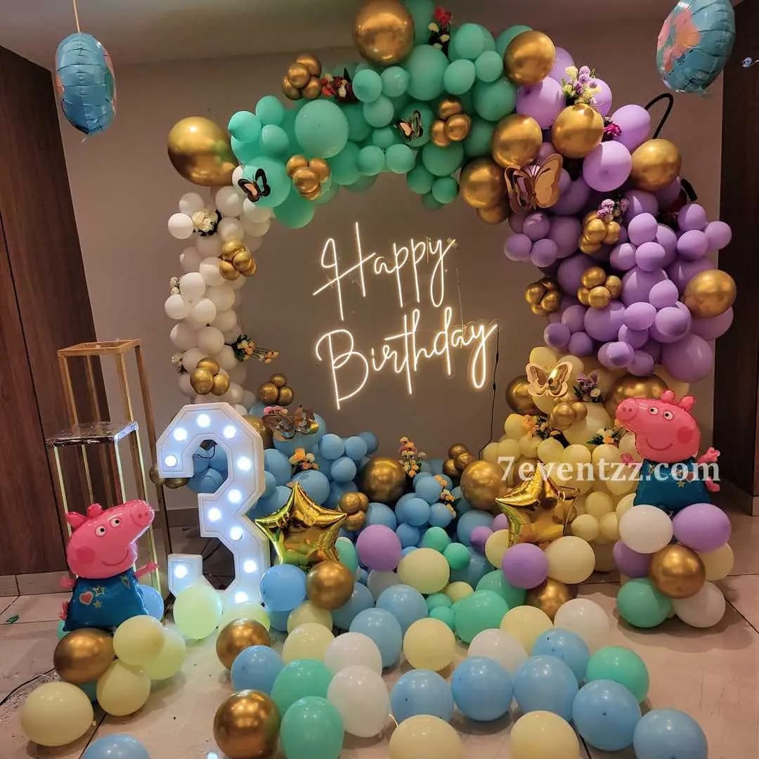 First birthday stage decoration with colorful backdrop and balloon arrangement
