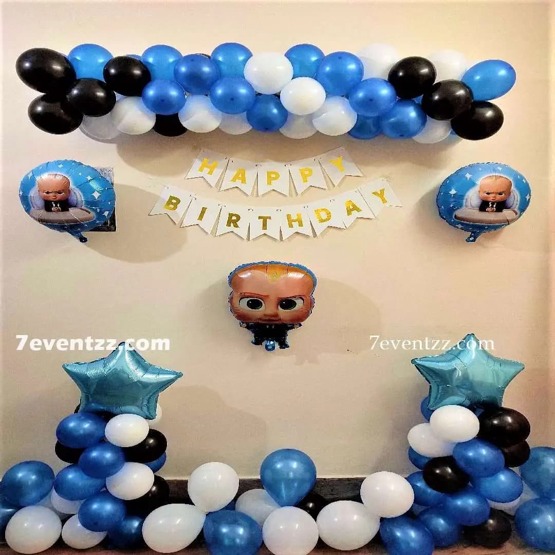Boss Baby birthday decoration setup with themed balloons and character cutout at home