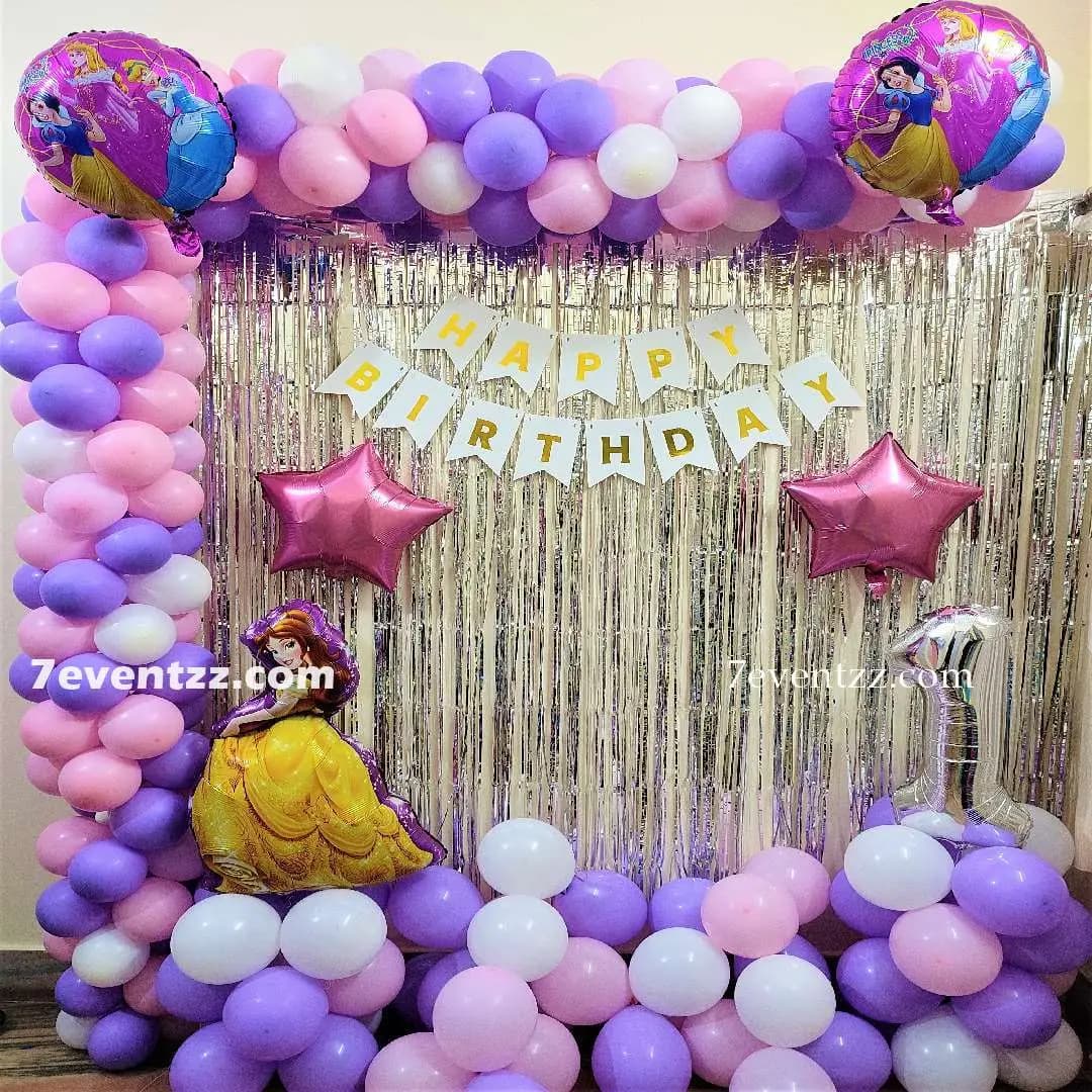 Princess themed birthday party decoration with pink and gold balloons and crown props