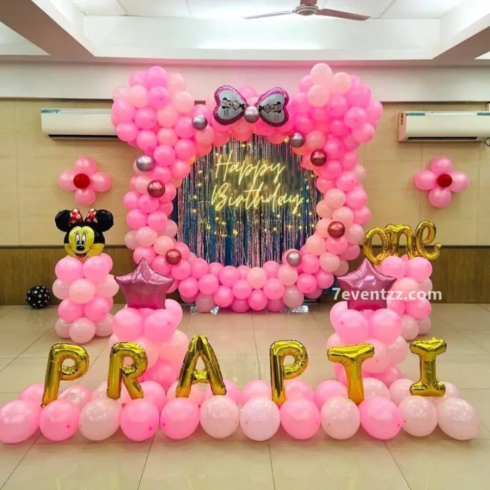 Minnie Mouse birthday decoration with pink and black themed balloon and character prop arrangement
