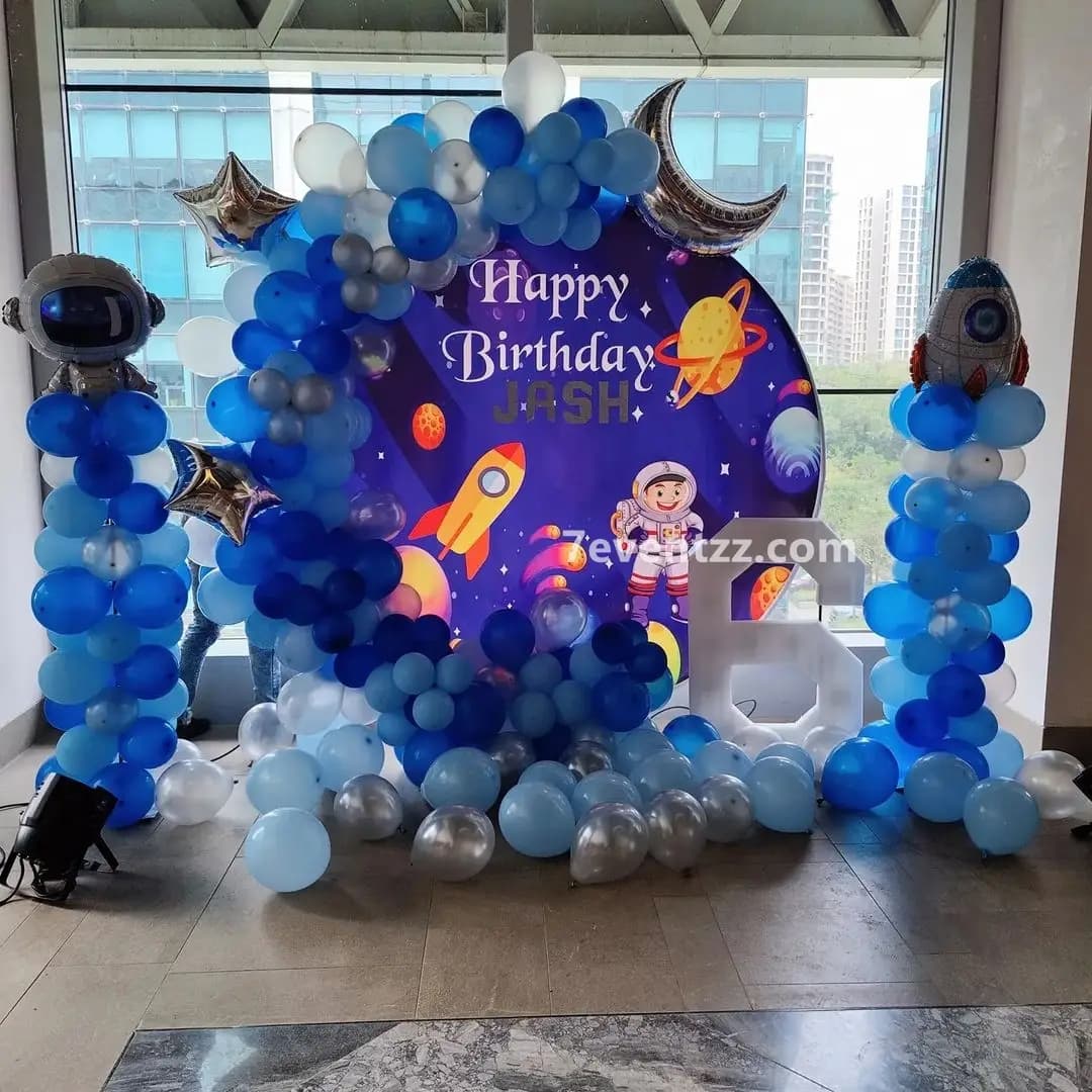 Space theme birthday party decoration with galaxy backdrop, planet balloons, and astronaut props