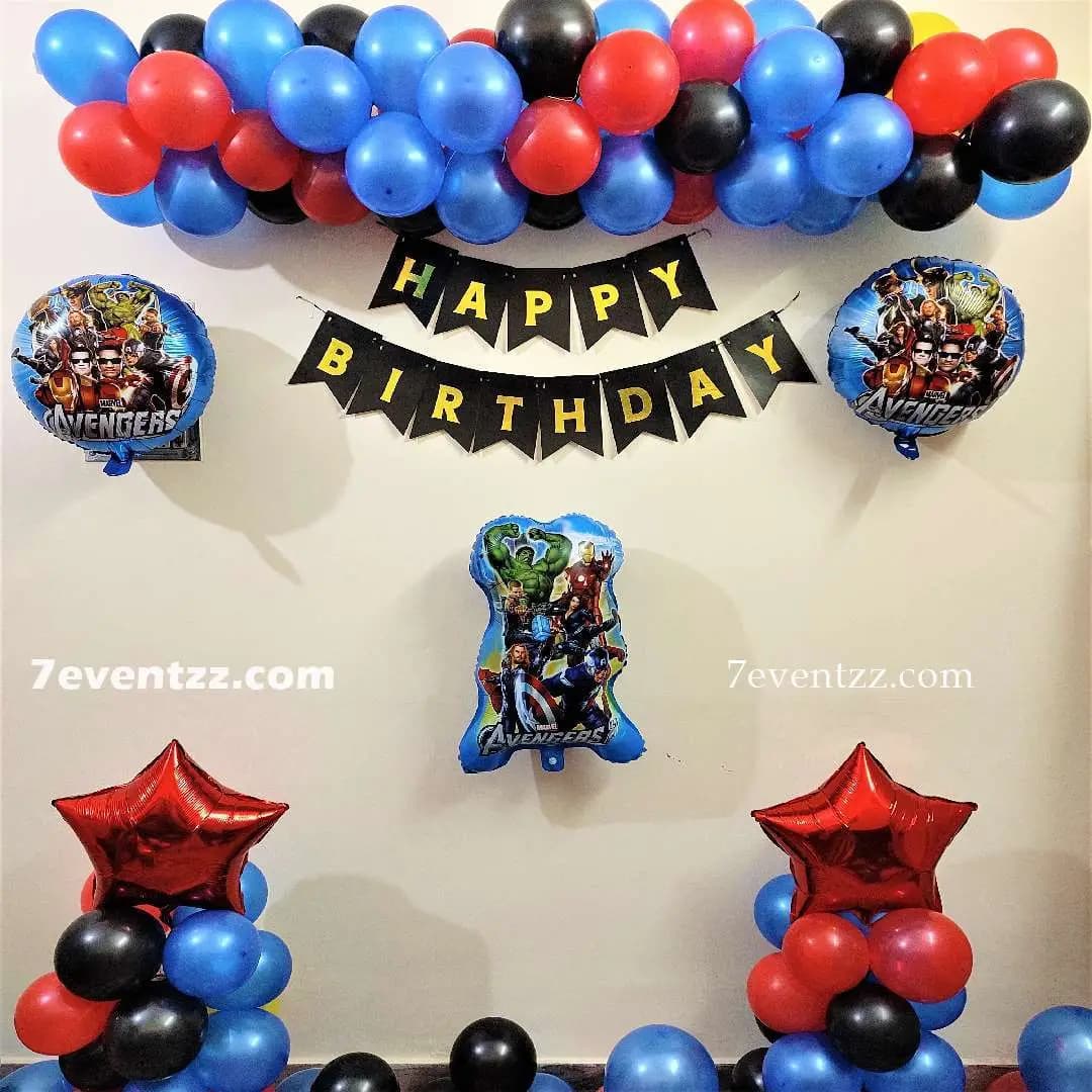Superhero themed kids birthday party decoration setup with colorful balloons and backdrop