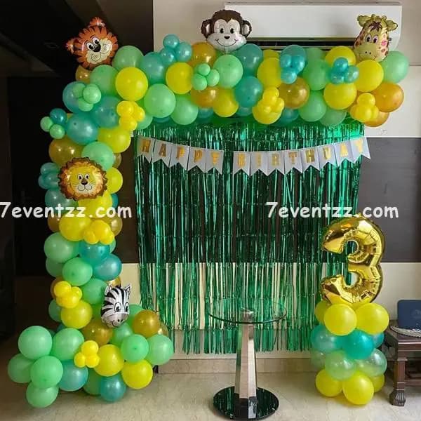 Simple jungle theme birthday decoration with green balloons and animal props