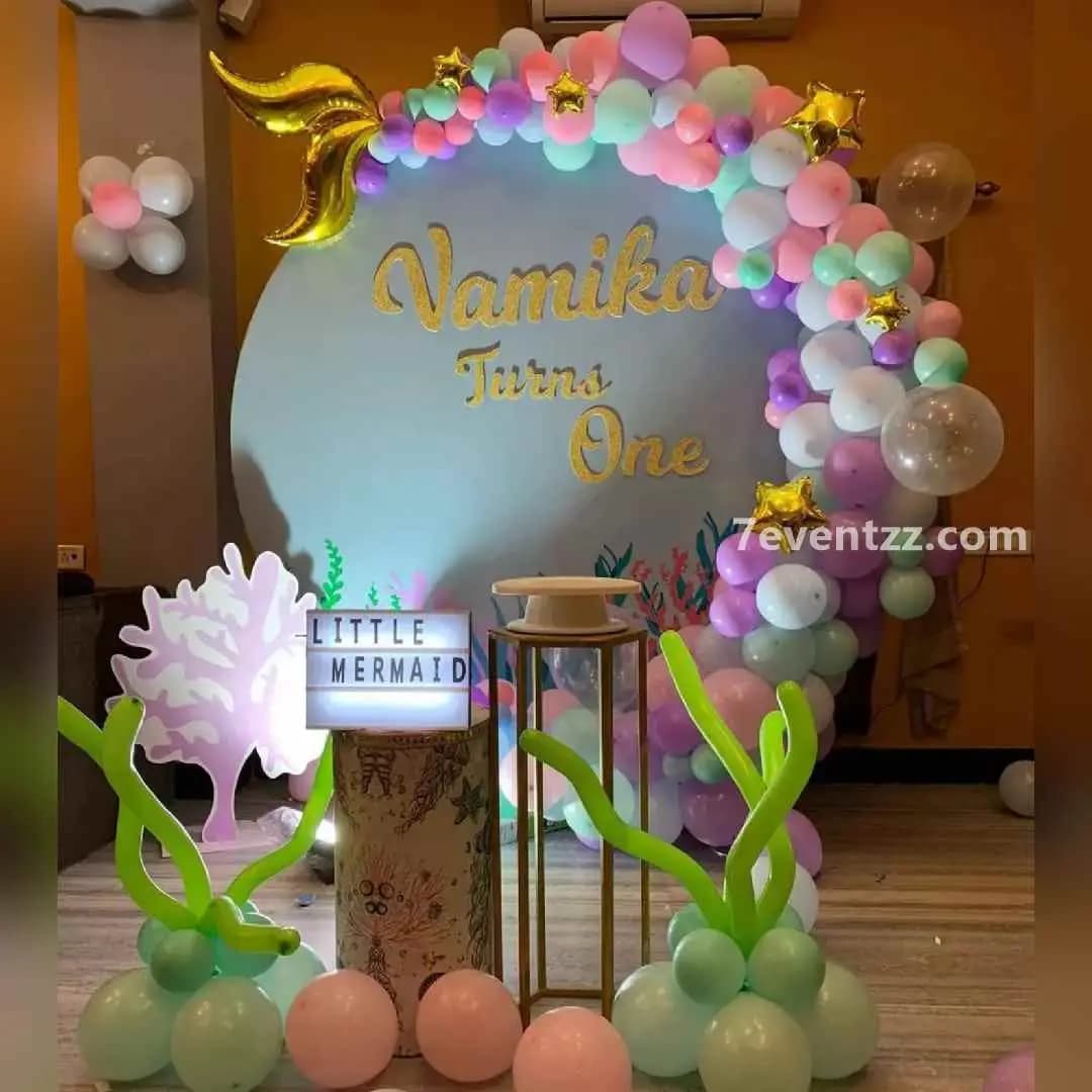 Mermaid backdrop decoration with pastel balloons, shimmering backdrop, and underwater theme props for kids birthday by 7eventzz