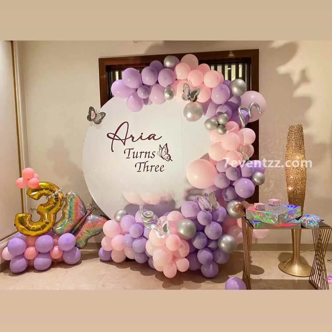 Butterfly pastel themed birthday decor with soft pink and lavender balloon setup