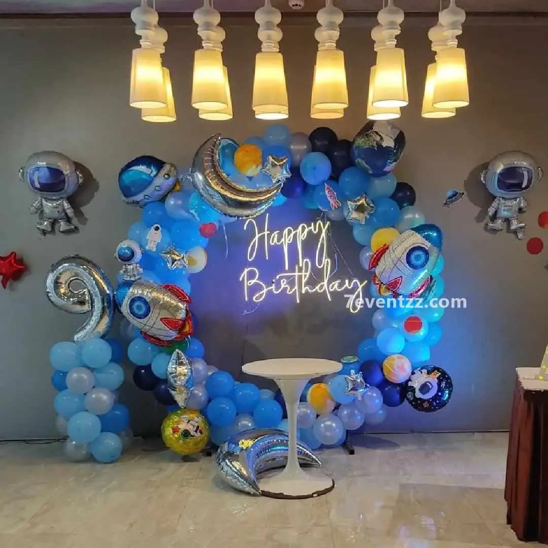 Space theme birthday decoration with planet and astronaut balloon setup