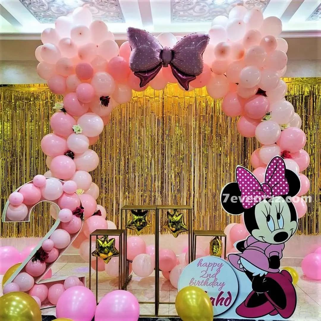 Minnie Mouse themed birthday stage decoration with character backdrop and pink balloons