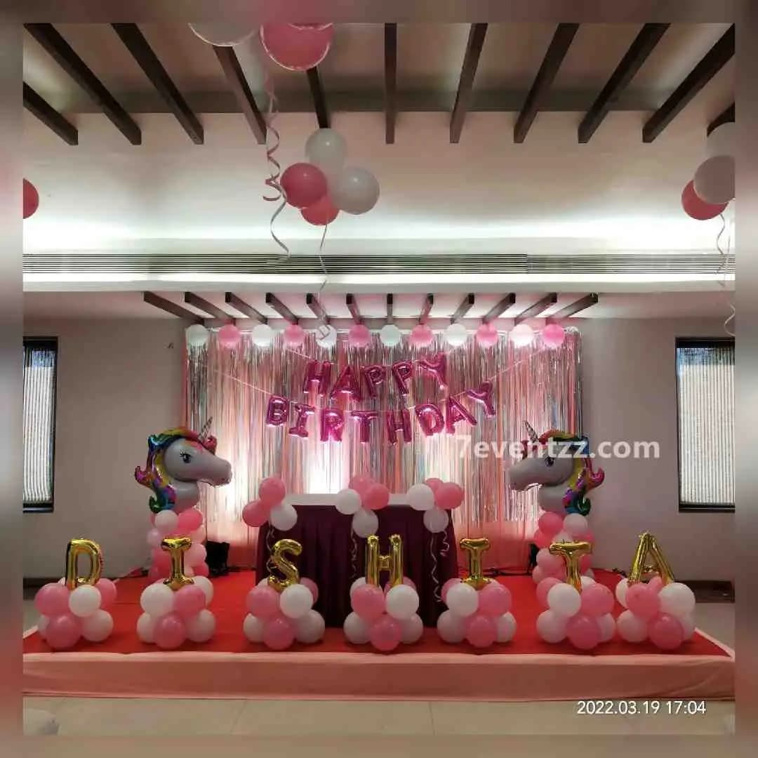 Simple unicorn stage decoration with pastel balloon arch and unicorn foil accents for birthday party