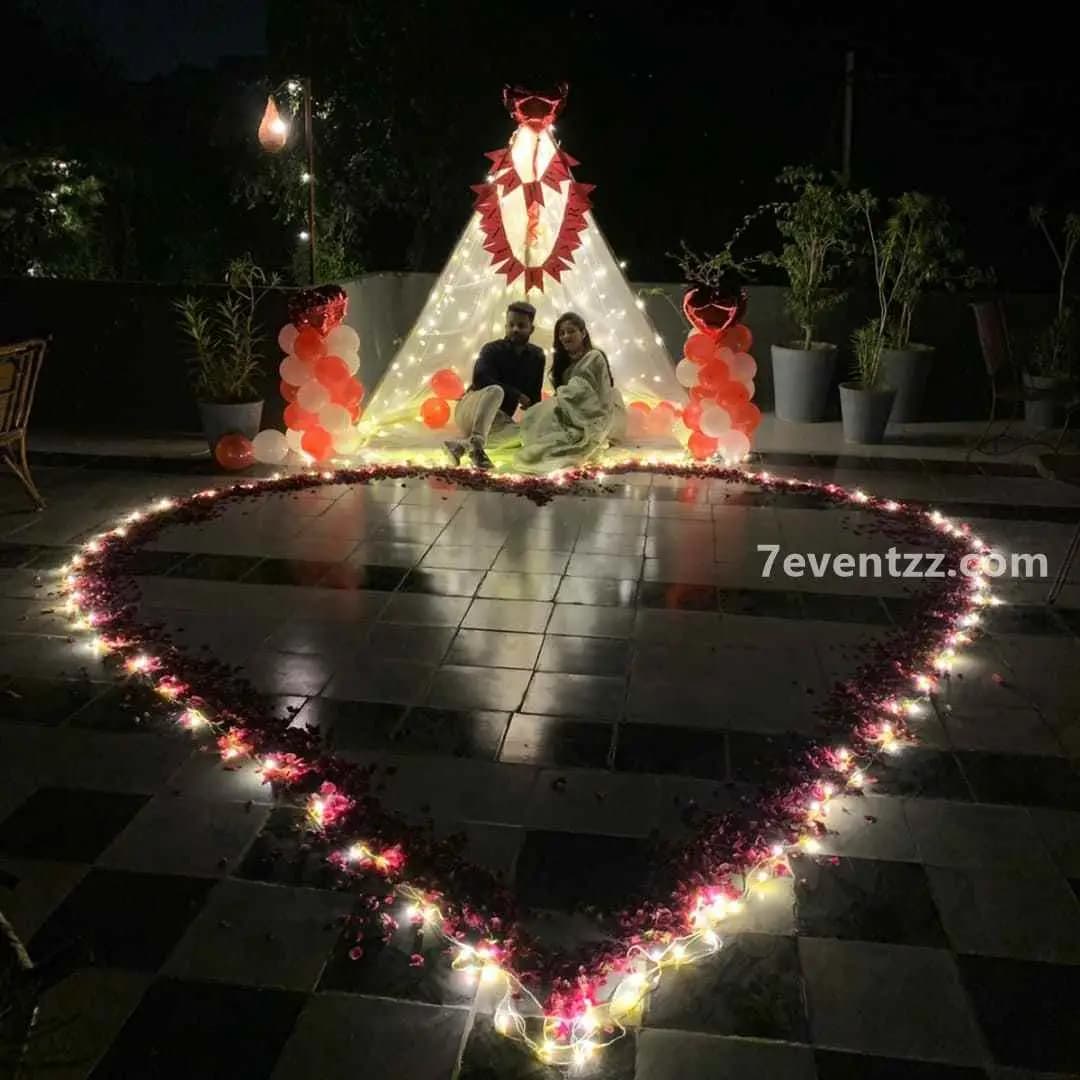 Terrace cabana setup for proposal with curtains, lights, and cozy seating