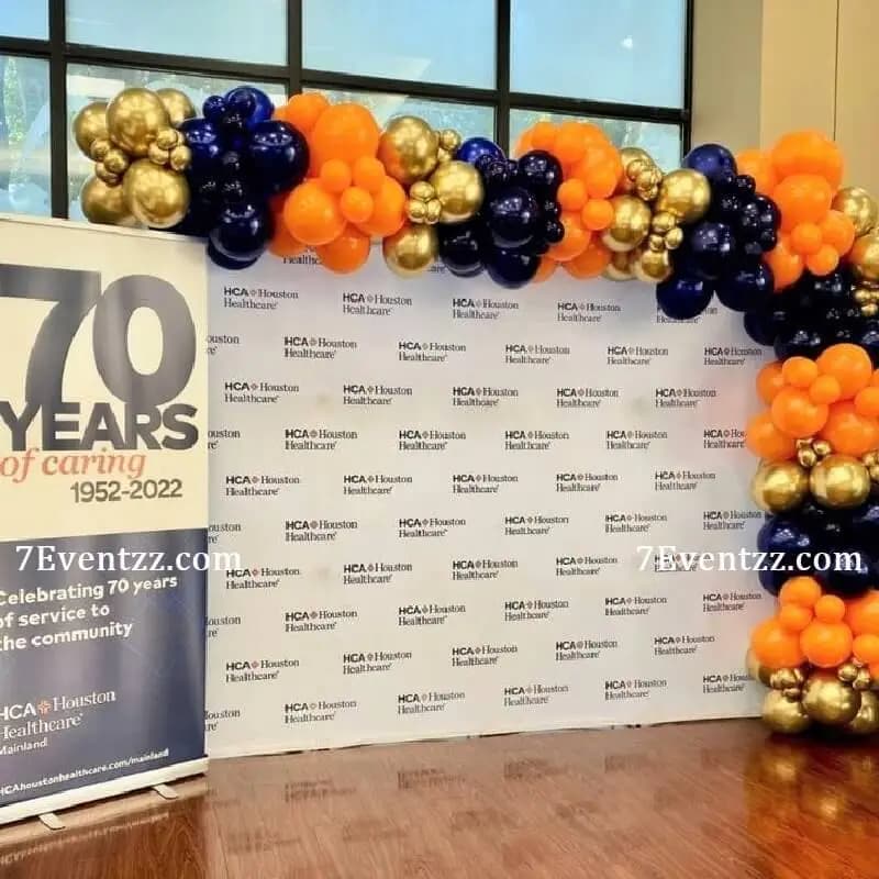 Decorated conference room with balloon arch and themed stage backdrop