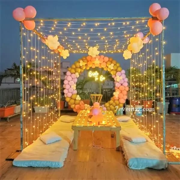 Bachelorette sitting decoration on terrace with pink balloon arrangement, fairy lights, and festive outdoor setup – 7eventzz