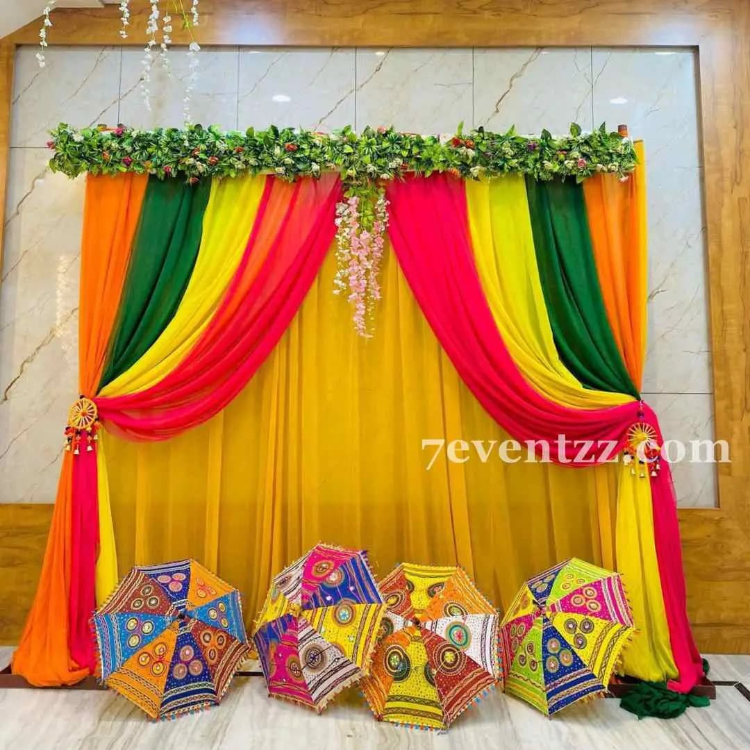 Colorful mehndi backdrop with vibrant flowers and decor
