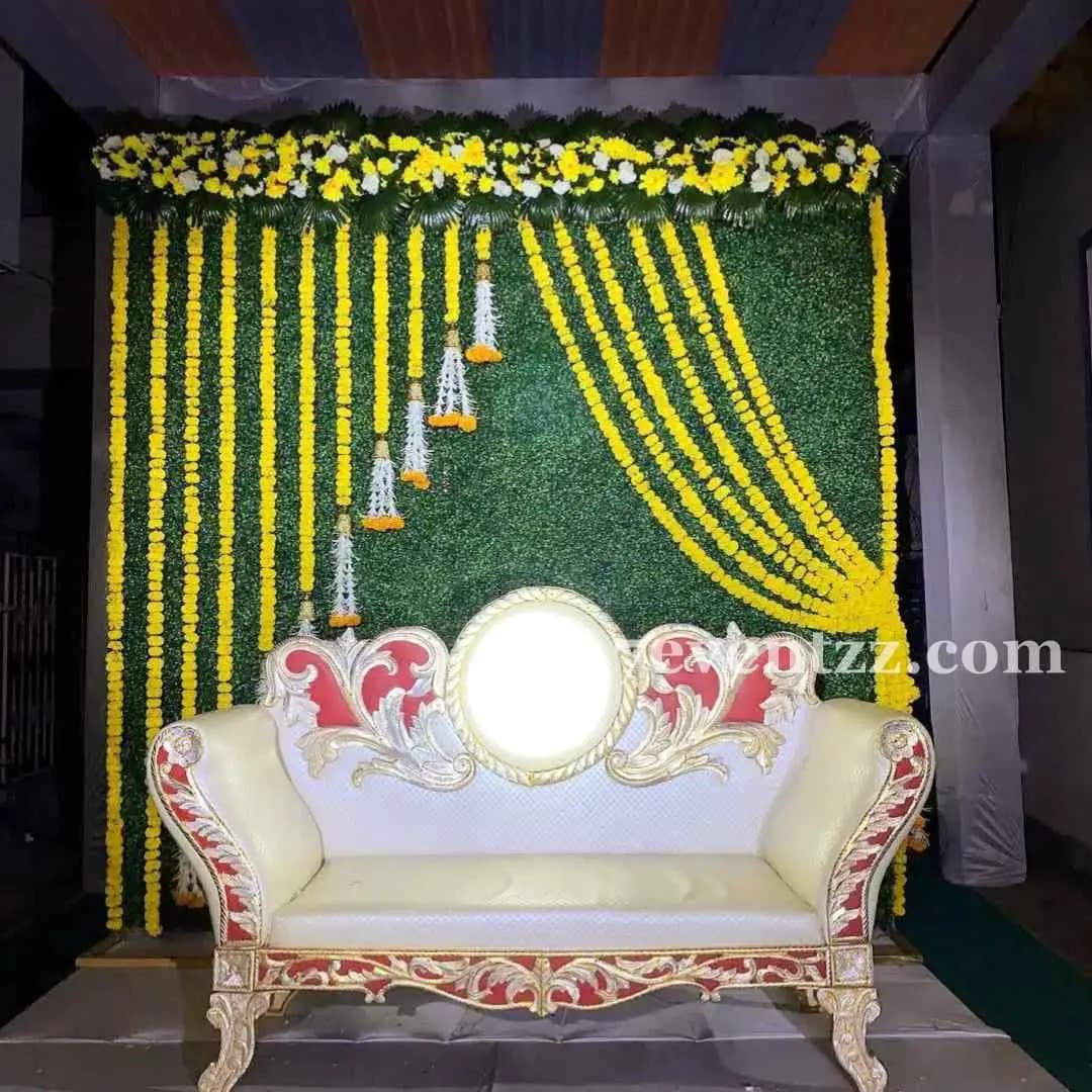 Green backdrop mehndi decoration setup with floral drapes