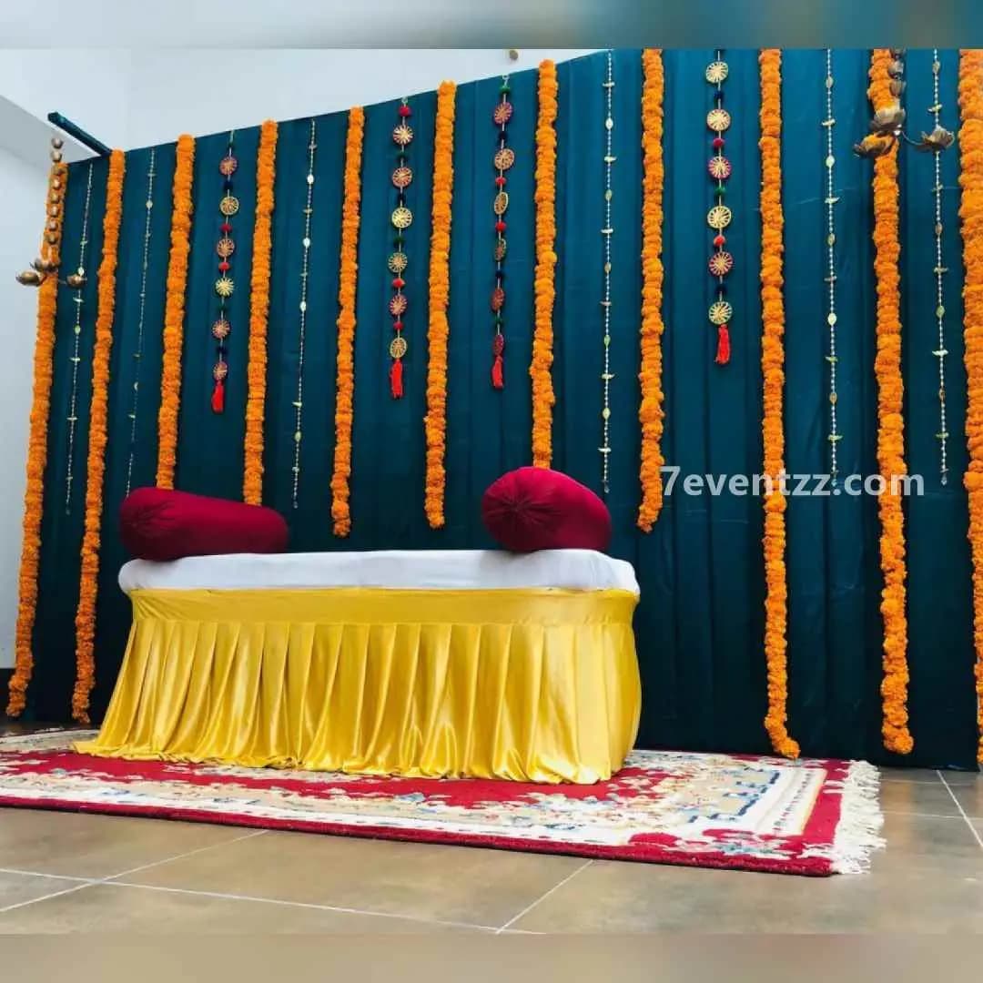 Mehndi ceremony home setup with floral backdrop and seating