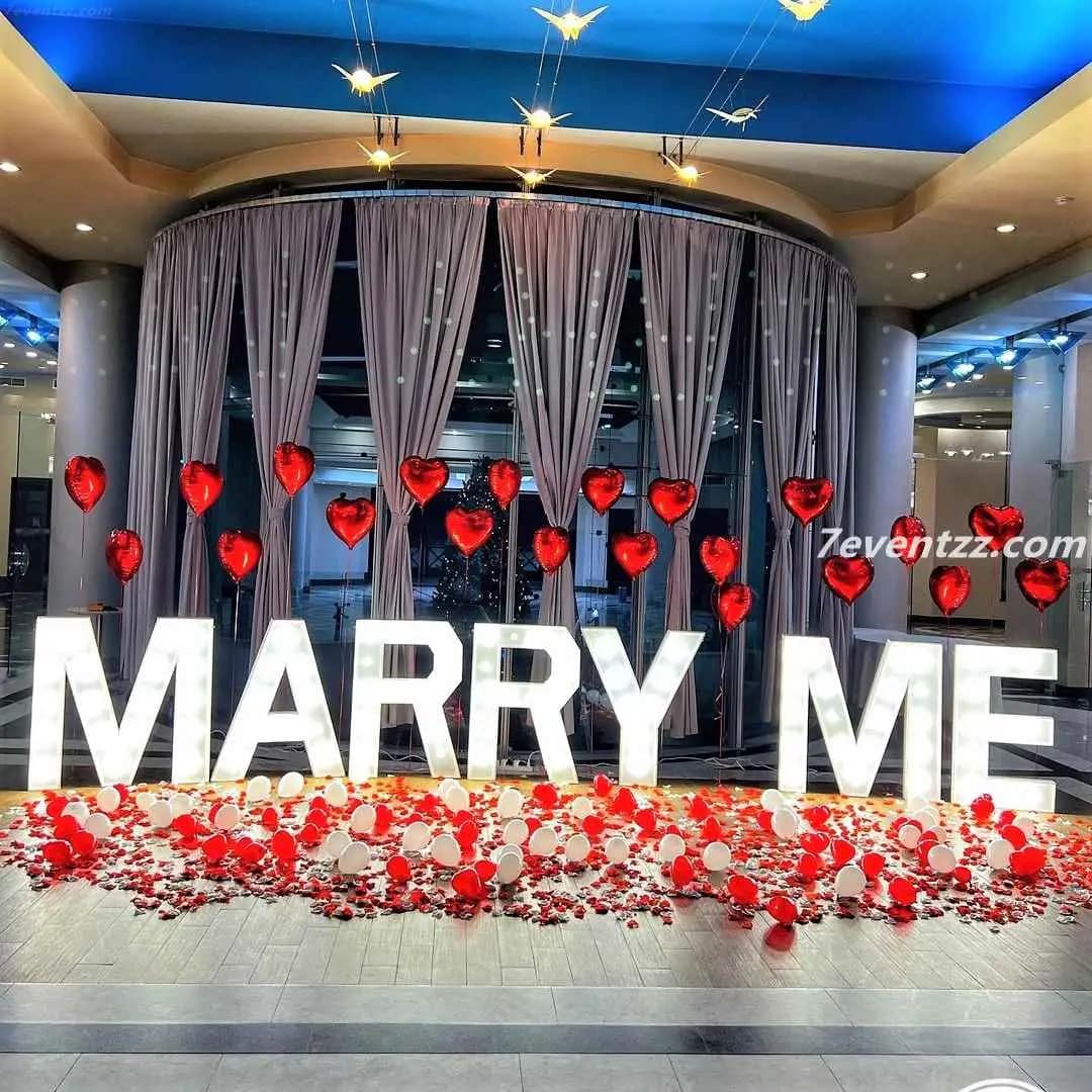 Grand wedding proposal setup with floral backdrop and candle arrangement