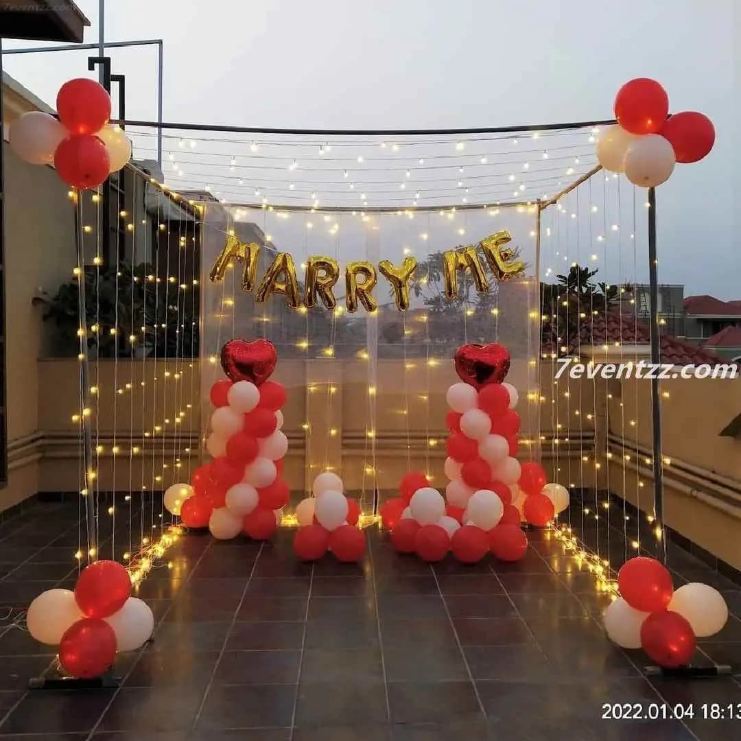 Terrace marry me decoration with string lights, balloons, and open-sky ambiance
